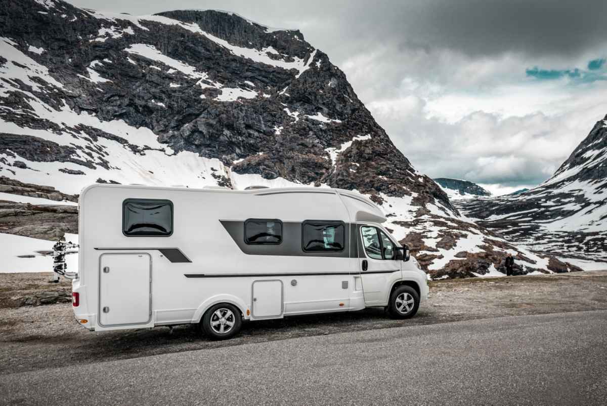 White camper on a snowy mountain road in Iceland.