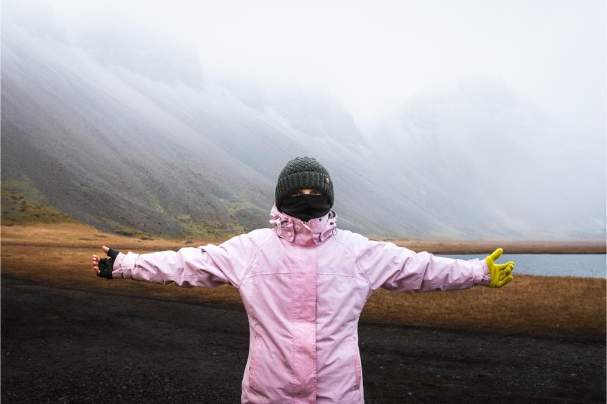 Woman with her arms wide open wearing a pink waterproof jacket